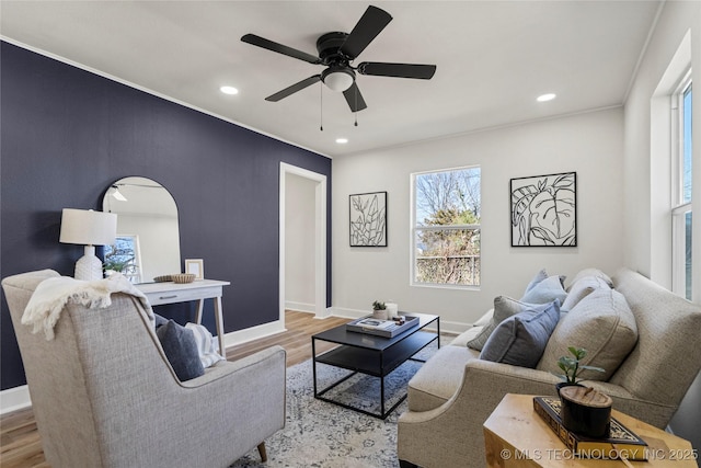 living room with wood finished floors, baseboards, and ceiling fan