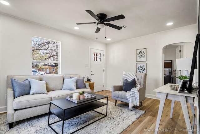 living room with visible vents, recessed lighting, arched walkways, light wood-style floors, and ceiling fan