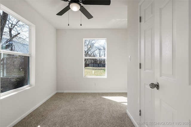 carpeted empty room with baseboards and ceiling fan