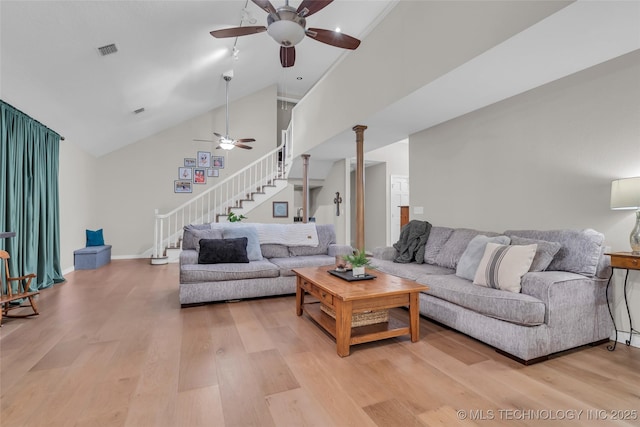 living room featuring stairs, visible vents, a ceiling fan, and light wood finished floors