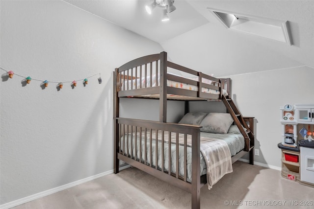 carpeted bedroom with baseboards and vaulted ceiling