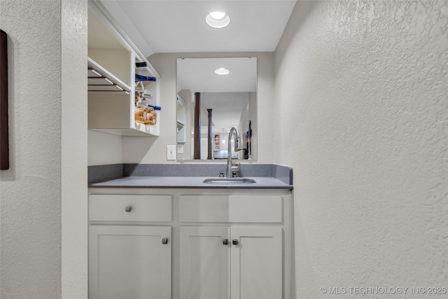 bathroom featuring vanity and a textured wall