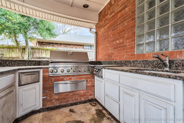 view of patio / terrace with a sink, fence, and a grill