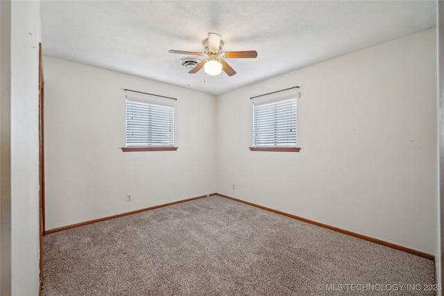 spare room featuring a wealth of natural light, baseboards, carpet, and a ceiling fan