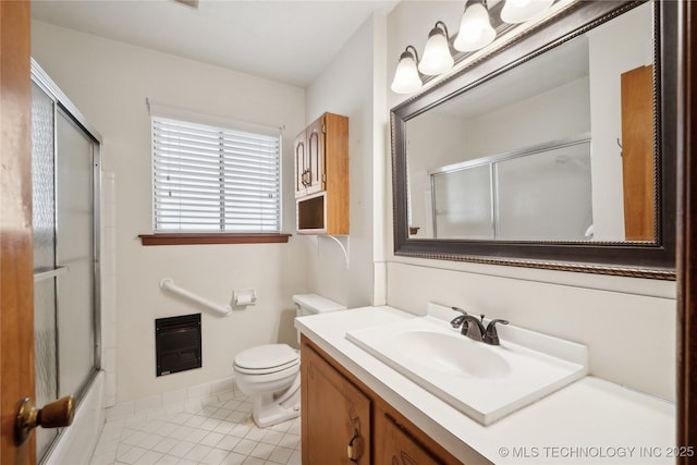 full bathroom with vanity, heating unit, shower / bath combination with glass door, tile patterned flooring, and toilet