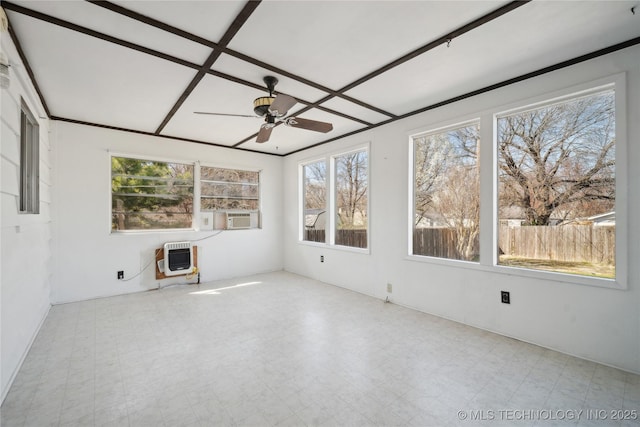 unfurnished sunroom featuring heating unit and ceiling fan