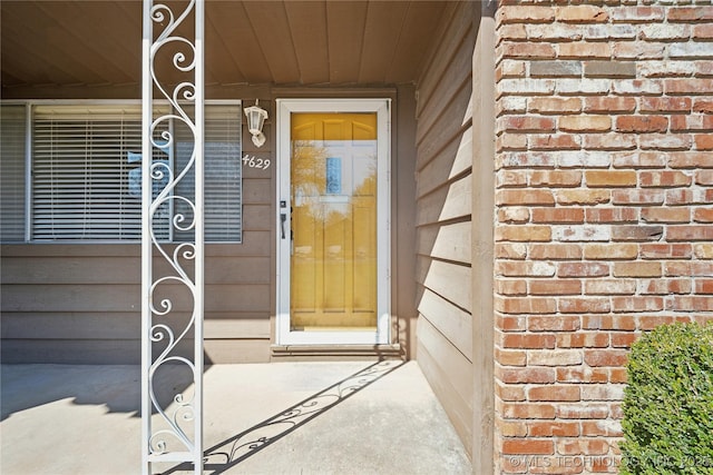 doorway to property featuring brick siding