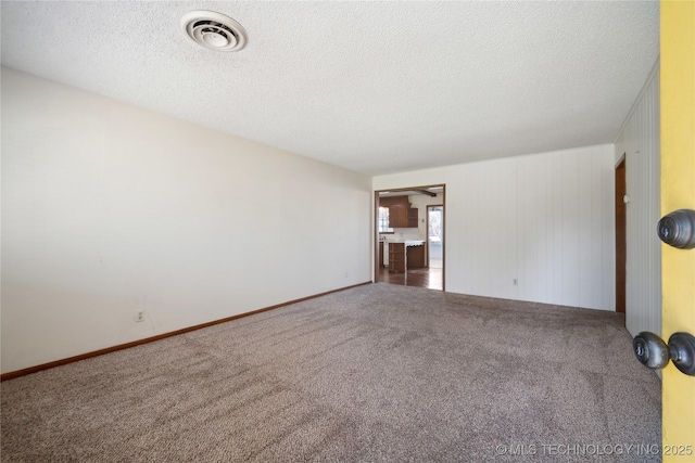 unfurnished room with visible vents, carpet floors, and a textured ceiling