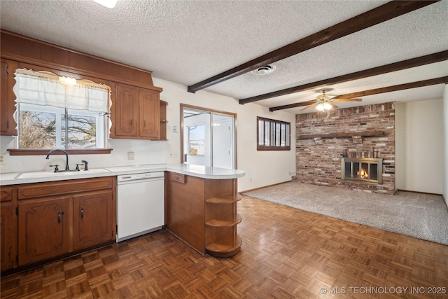 kitchen with a sink, light countertops, a peninsula, white dishwasher, and open shelves