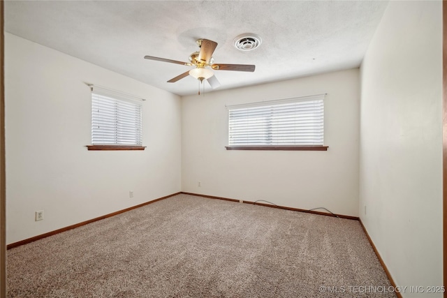 empty room featuring visible vents, carpet flooring, baseboards, and a ceiling fan