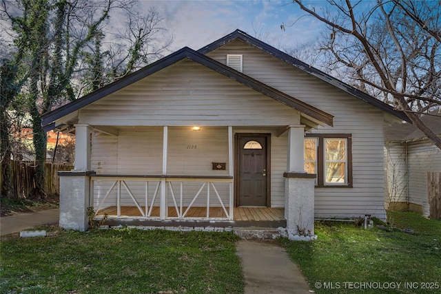 bungalow-style home featuring a front yard and fence