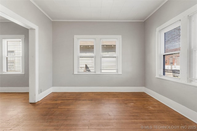 empty room with plenty of natural light, baseboards, and wood-type flooring