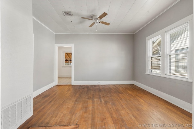 spare room featuring visible vents, ornamental molding, a ceiling fan, and hardwood / wood-style flooring