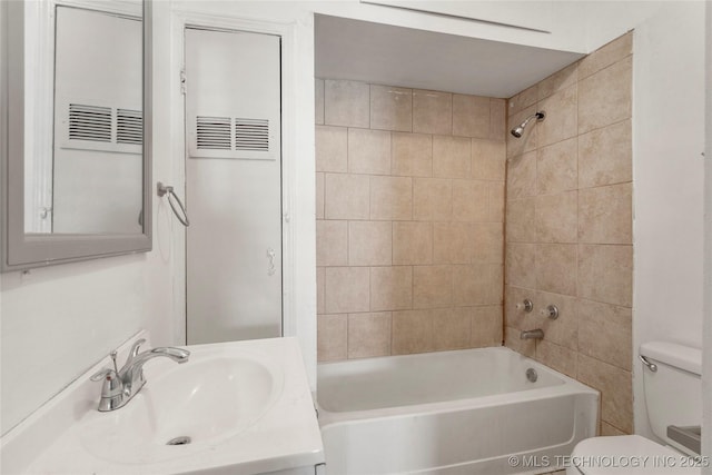 bathroom with bathtub / shower combination, toilet, and vanity