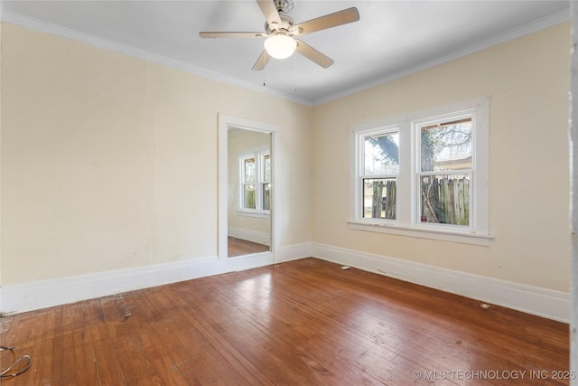 spare room with baseboards, hardwood / wood-style floors, a ceiling fan, and ornamental molding