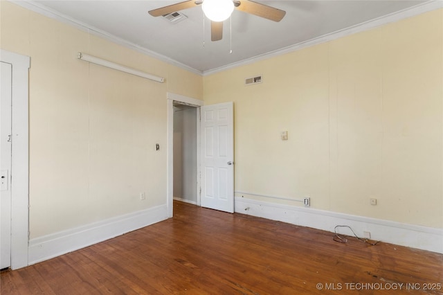 unfurnished room featuring visible vents, wood finished floors, and ornamental molding