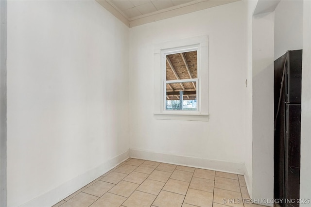 spare room with light tile patterned flooring, baseboards, and ornamental molding