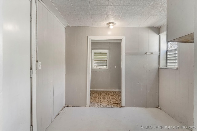 interior space with concrete floors, wood walls, and a wealth of natural light