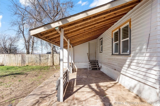 view of patio / terrace with entry steps, an attached carport, and fence