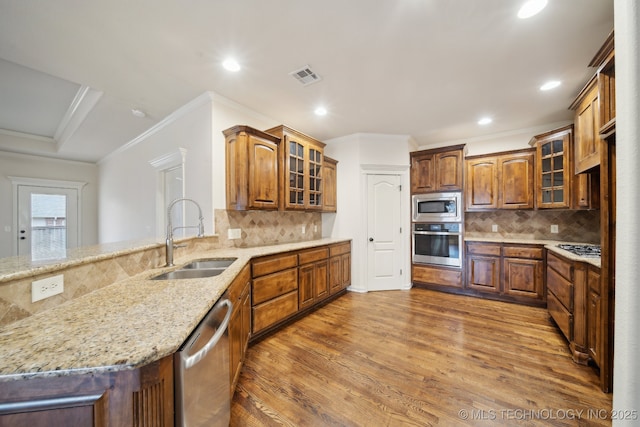 kitchen featuring a sink, stainless steel appliances, visible vents, and brown cabinetry