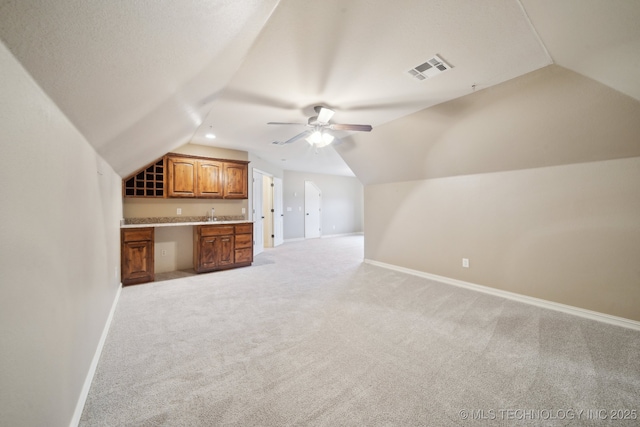 bonus room with light carpet, visible vents, baseboards, and lofted ceiling