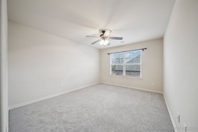 carpeted spare room featuring visible vents, baseboards, and a ceiling fan