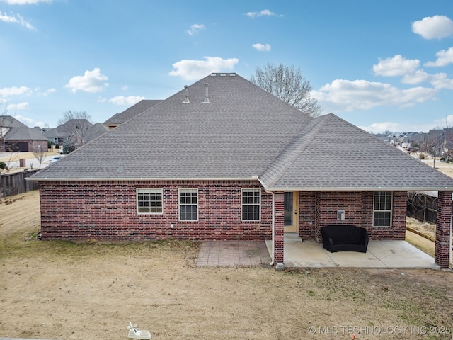 back of property featuring a patio area, brick siding, and roof with shingles