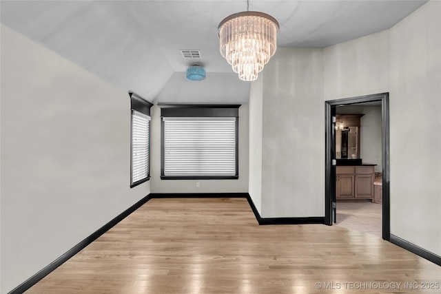 unfurnished room featuring visible vents, baseboards, an inviting chandelier, and light wood finished floors