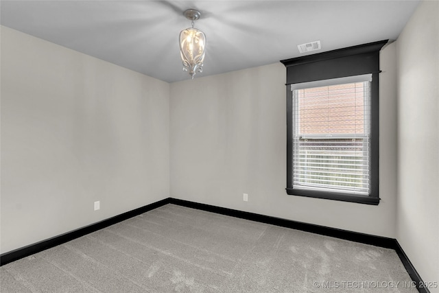 spare room featuring visible vents, carpet, and baseboards