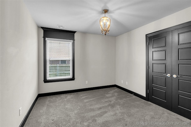 carpeted empty room with visible vents and baseboards