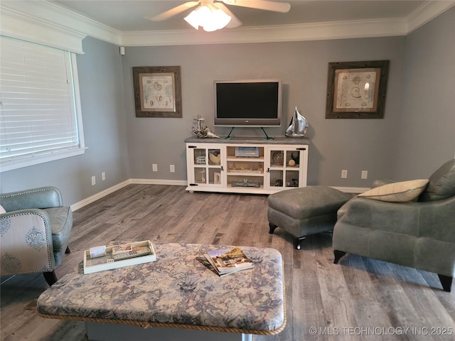 living room featuring ceiling fan, baseboards, wood finished floors, and crown molding