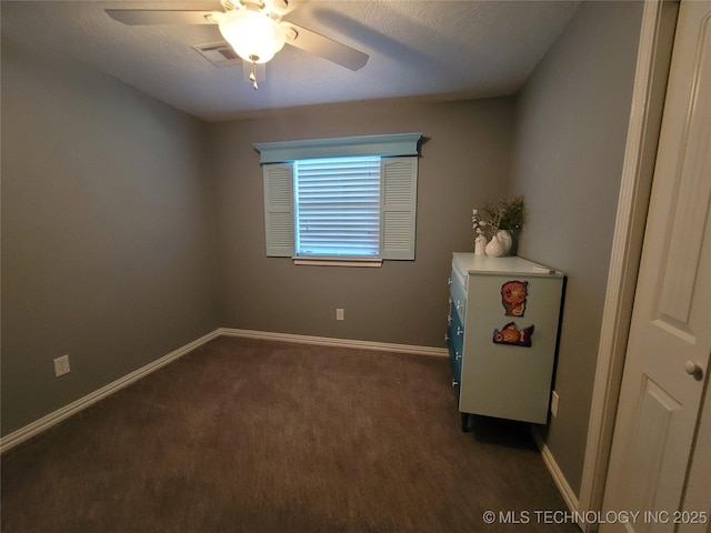 empty room featuring visible vents, a ceiling fan, and baseboards