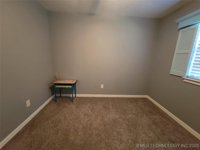 carpeted spare room featuring baseboards