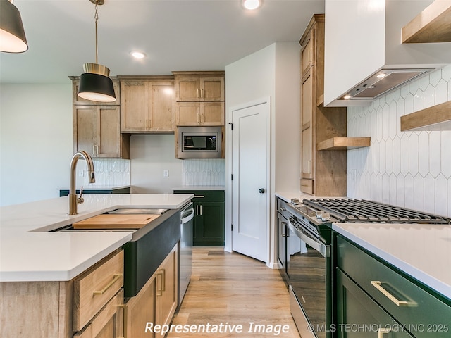 kitchen with wall chimney range hood, light countertops, decorative backsplash, stainless steel appliances, and open shelves