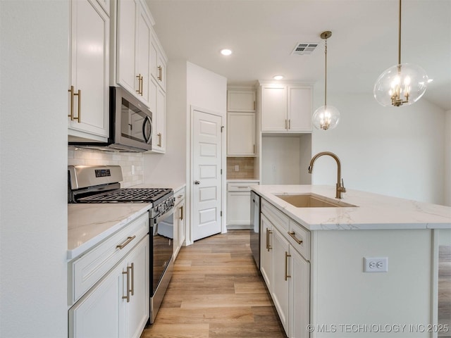 13404 E 123rd Pl, Collinsville, OK 74021 - kitchen with white cabinets, a sink, visible vents, light wood-style floors, and appliances with stainless steel finishes