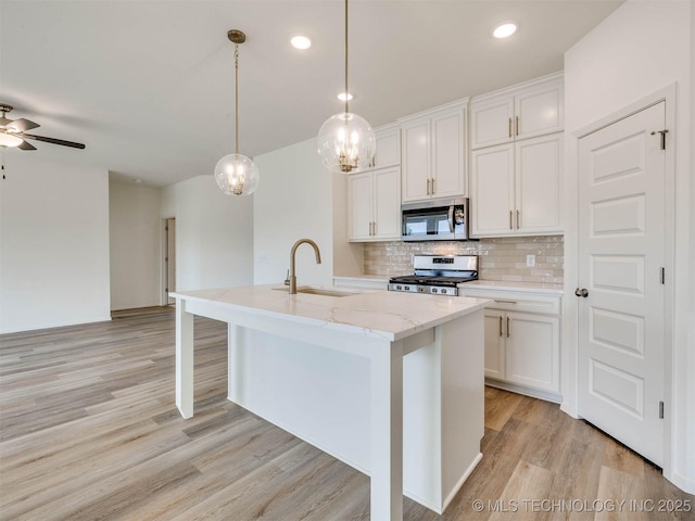 13404 E 123rd Pl, Collinsville, OK 74021 - kitchen with a sink, white cabinets, light wood finished floors, backsplash, and appliances with stainless steel finishes