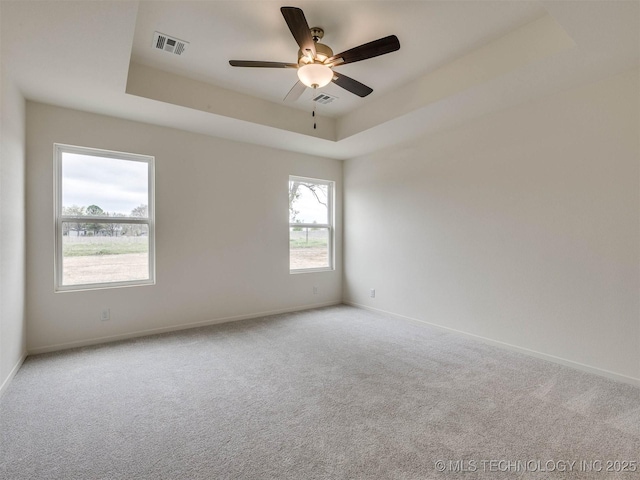 13404 E 123rd Pl, Collinsville, OK 74021 - carpeted spare room featuring a tray ceiling, visible vents, a ceiling fan, and baseboards