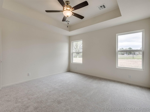13404 E 123rd Pl, Collinsville, OK 74021 - carpeted empty room with baseboards, visible vents, ceiling fan, and a tray ceiling