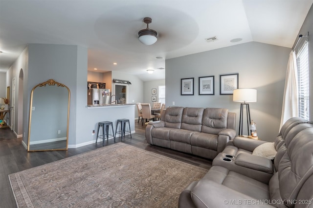 living area featuring visible vents, a healthy amount of sunlight, and vaulted ceiling