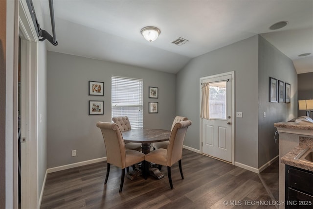 dining space featuring lofted ceiling, dark wood-style floors, visible vents, and baseboards