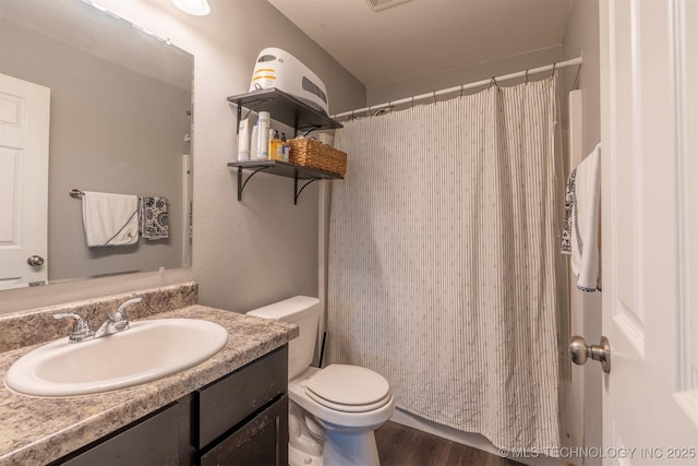 bathroom with curtained shower, toilet, wood finished floors, and vanity