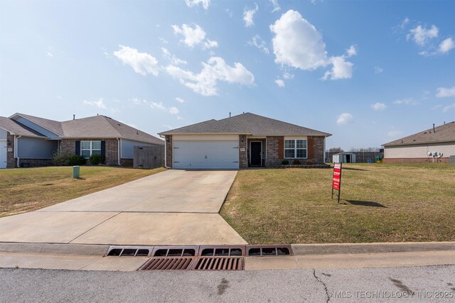 ranch-style home featuring a front yard, central AC unit, an attached garage, concrete driveway, and brick siding