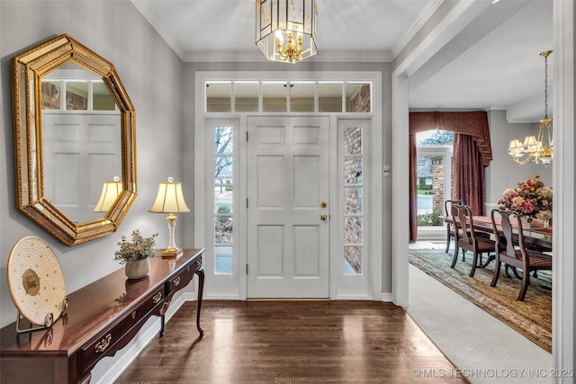 entryway with a wealth of natural light, wood finished floors, an inviting chandelier, and ornamental molding