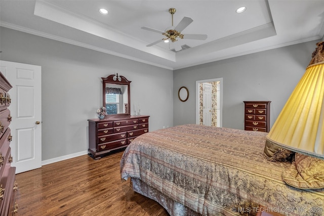 bedroom with crown molding, a raised ceiling, and wood finished floors