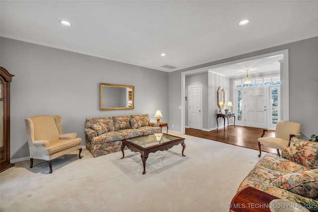 living area with visible vents, baseboards, recessed lighting, ornamental molding, and a chandelier