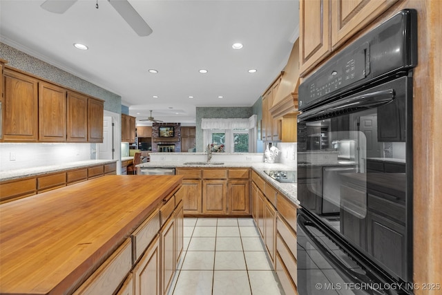 kitchen with wooden counters, light tile patterned floors, a peninsula, black appliances, and a ceiling fan