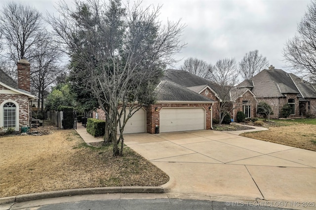 view of front facade featuring a front lawn, fence, concrete driveway, a garage, and brick siding