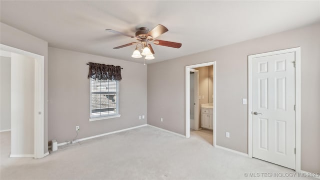 unfurnished bedroom featuring connected bathroom, baseboards, light colored carpet, and a ceiling fan