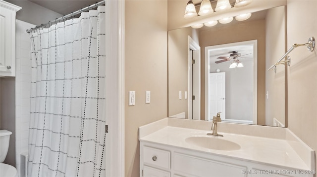 bathroom featuring a shower with curtain, vanity, toilet, and a ceiling fan