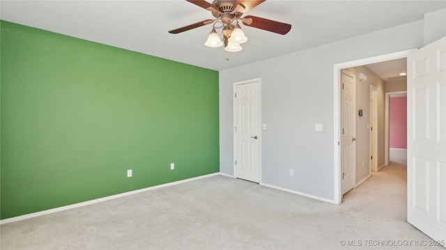 unfurnished bedroom featuring baseboards, carpet floors, a closet, and ceiling fan